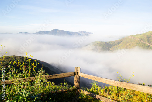 Wooden fence overlooking misty mountain valley in early morning light