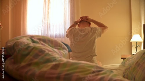 Man Stretching in Bed During Morning Light, Quiet Bedroom Scene 