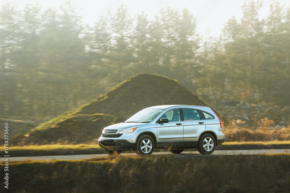 Fototapeta premium SUV journey along country road at golden hour