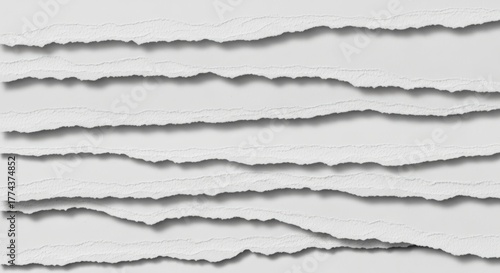 Close-up of torn paper strips arranged horizontally, showcasing rough edges and textures, creating a layered effect.