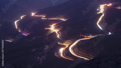 Time lapse of light car traffic moving at night on the road at Jable Jai, Ras Al Khaimah, United Arab Emirates.
