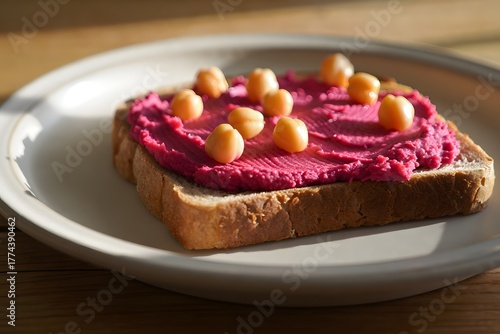 Beet hummus and chickpea toast on a white plate in the morning sunlight food photography