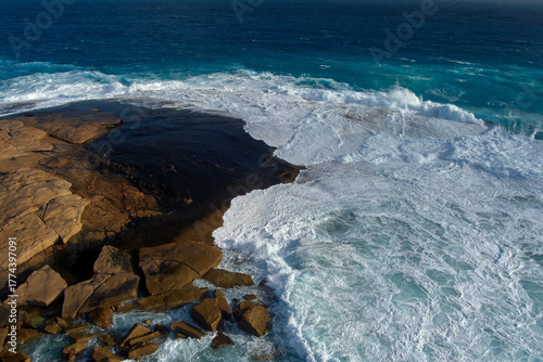 Pounded over centuries by rugged surf, the rock surface is ground smooth