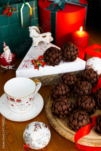 Christmas or New Year sponge cakes cones with holiday gifts, red candle, christmas tree toys and red ribbons