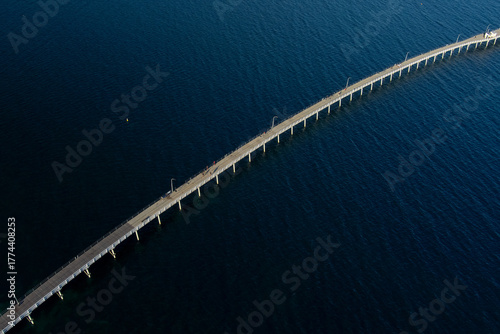 Photos A white bridge stretches over the sea, contrasting the vivid blue tones of the o