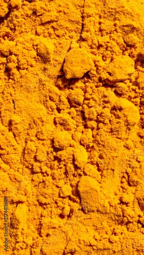 Macro close up turmeric powder surface showing natural spice texture and organic detail