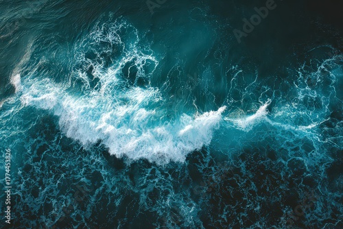 Aerial View of Crashing Ocean Wave with Foamy White Spray and Dark Teal Water in Sunlight