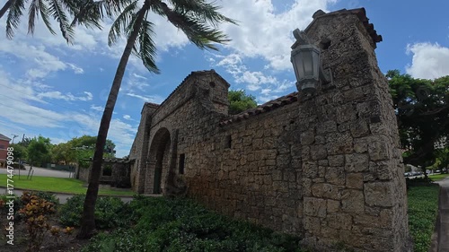 A shot of the historic Alhambra Water Gate, a Mediterranean Revival entrance monument in Coral Gables, Florida, under a clear sky.