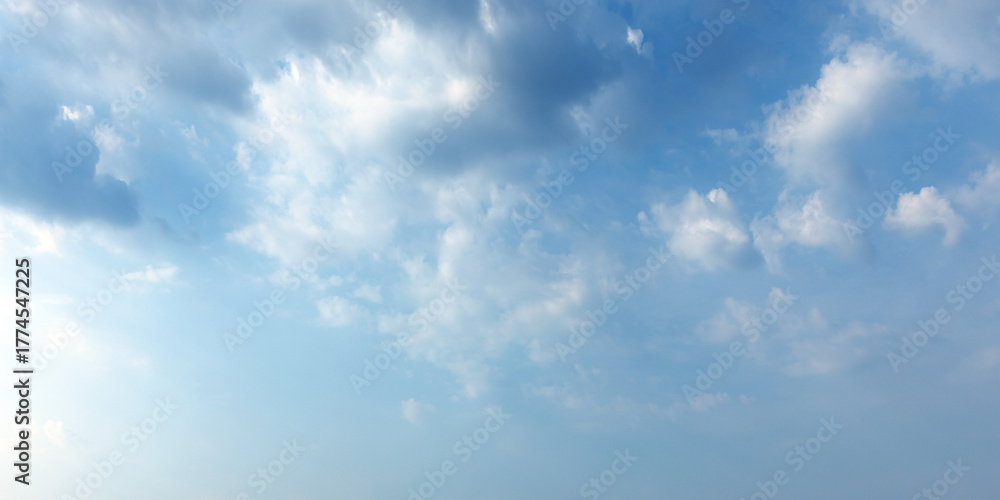 Fototapeta premium A serene bright blue sky filled with fluffy white clouds