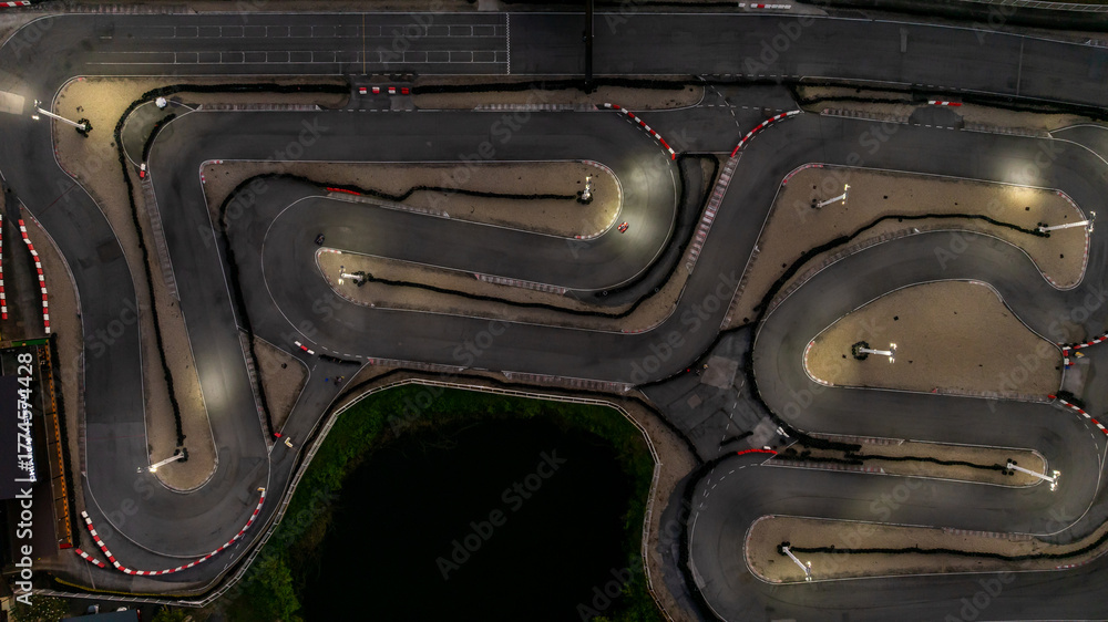 Naklejka premium Aerial top view race kart track at night, Track for auto racing top view at night, Car race asphalt and curve street circuit, Aerial view asphalt race track at night.