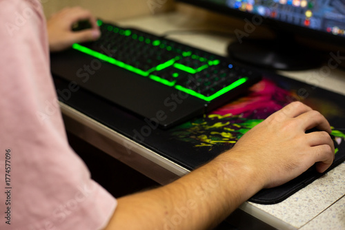 Gamer hand on mouse, other hand on keyboard. Professional hand position of video game player on modern backlit mechanical keyboard. Concept from the video game industry