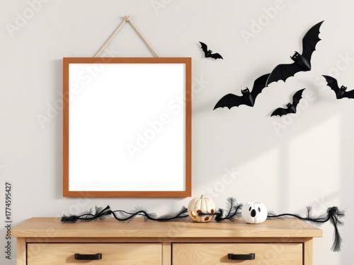 Blank halloween picture frame on dresser with bat decorations and spooky garland