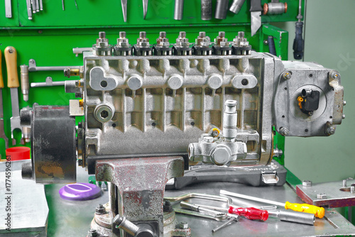 repair of fuel pump of eight-cylinder diesel engine view of assembled pump installed on workbench In vice