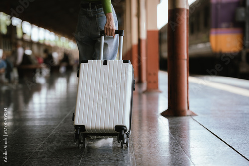 Fotografía Traveler pulling a suitcase at a train station, representing travel, journey, transportation, and exploration