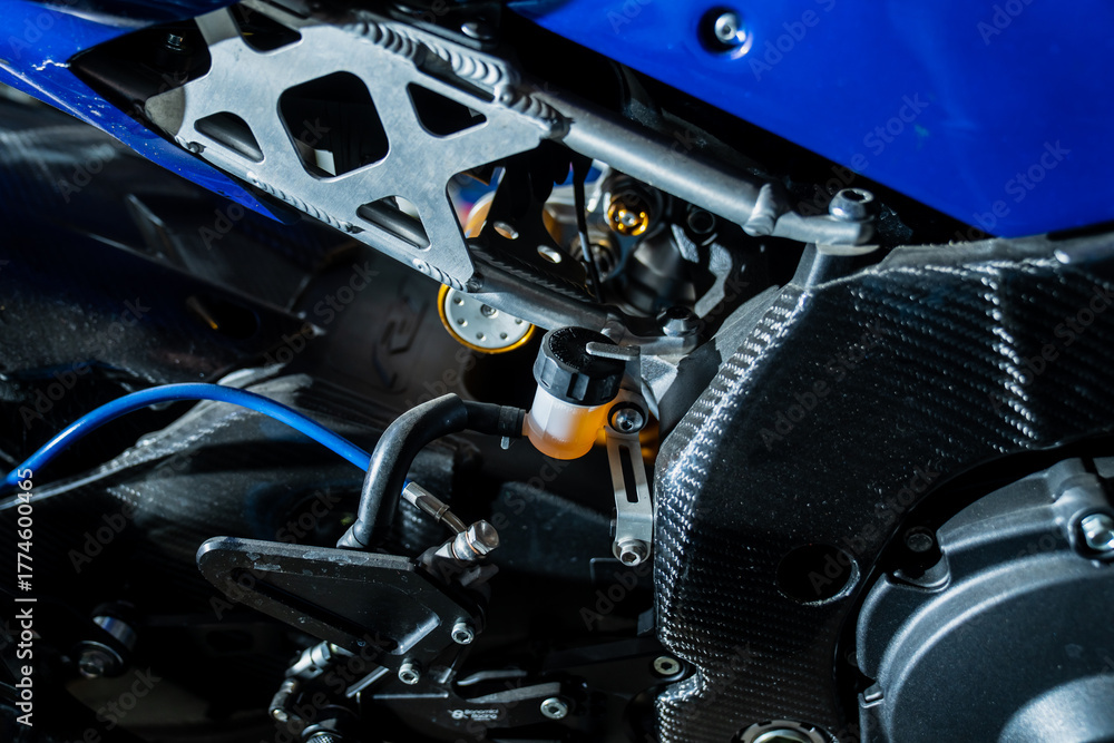Fototapeta premium Sport motorcycle mechanical detail with carbon fiber body, metal frame, and hydraulic brake reservoir representing technology, speed, and modern engineering in high-performance motorbike design