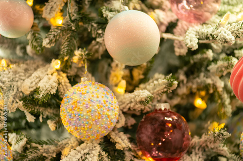 Colorful Christmas baubles on snowy tree branches