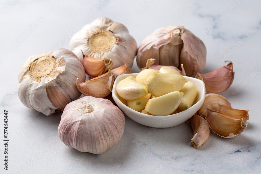 Fototapeta premium Bulbs and cloves of fresh garlic on table, closeup