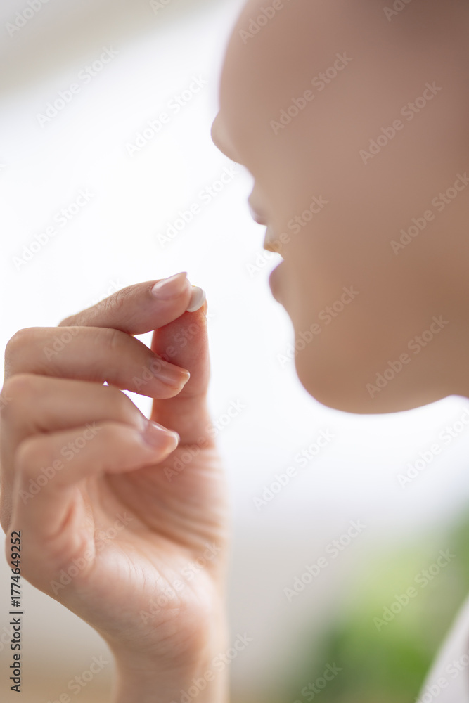 Naklejka premium Close-up of a pill held between fingers