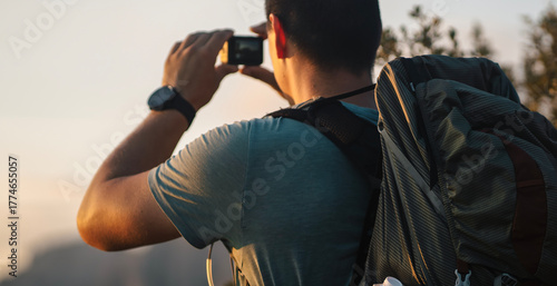 Bild auf Leinwand A man holding an action camera a in his hands, makes photo of mountains