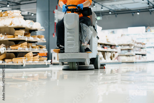 worker is cleaning floor with machine
