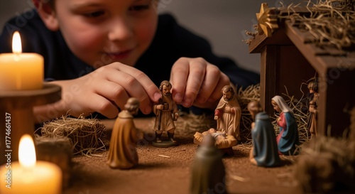 Boy plays with Nativity scene, arranging figurines around creche on Christmas time. Nativity scene recalls religious roots of Christmas time.