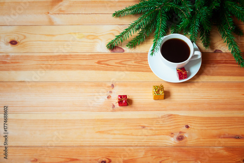 Cup of coffee and christmas gifts on wooden table. Top view, copy space.