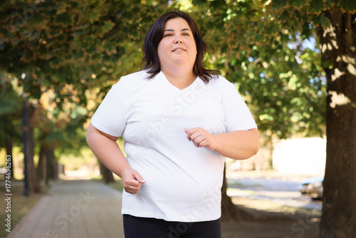 Overweight woman running in park. Healthy lifestyle