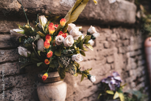 Artificial flower bouquet decorating old stone wall