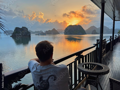 Man watching sunset from boat on Ha Long Bay