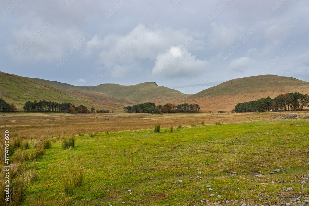 Obraz premium The serene beauty of Bannau Brycheiniog, featuring the majestic escarpment of Corn Du, Pen Y Fan, and Cribyn above the picturesque Taf Fechan river basin at the decommissioned Upper Neuadd Reservoir