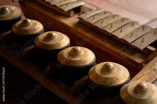 Close-up of traditional Javanese gamelan instruments with bronze gongs and metal bars.