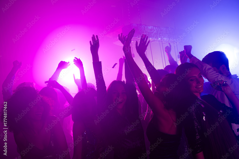 Φωτογραφία Friends and crowd celebrate vibrant nightclub party neon purple pink lights danc