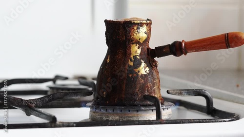 Coffee boiling over from turk and extinguishing gas stove flame during cooking process