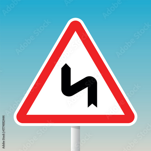 Double bend road warning sign (right then left) with red triangle and pole for traffic hazard alerts