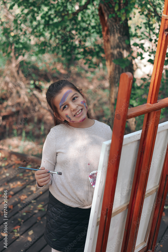 Obraz premium little girl painting in the forest