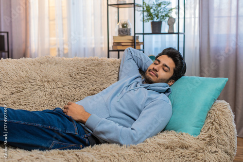 Photography Tired Indian man lying down on comfortable couch, taking rest, daytime nap