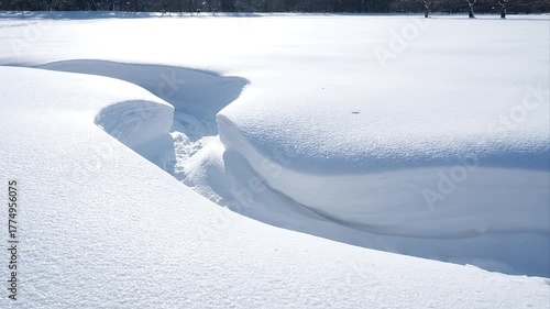 Vast pristine white snow landscape on a clear winter day with deep snowdrifts and textured snow formations in a serene natural outdoor scene