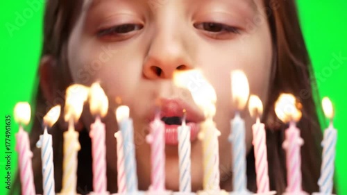 Wallpaper Mural Closeup of a young girl with long hair blowing out birthday candles on a cake celebrating her special day with joy and excitement on a green screen background. Torontodigital.ca
