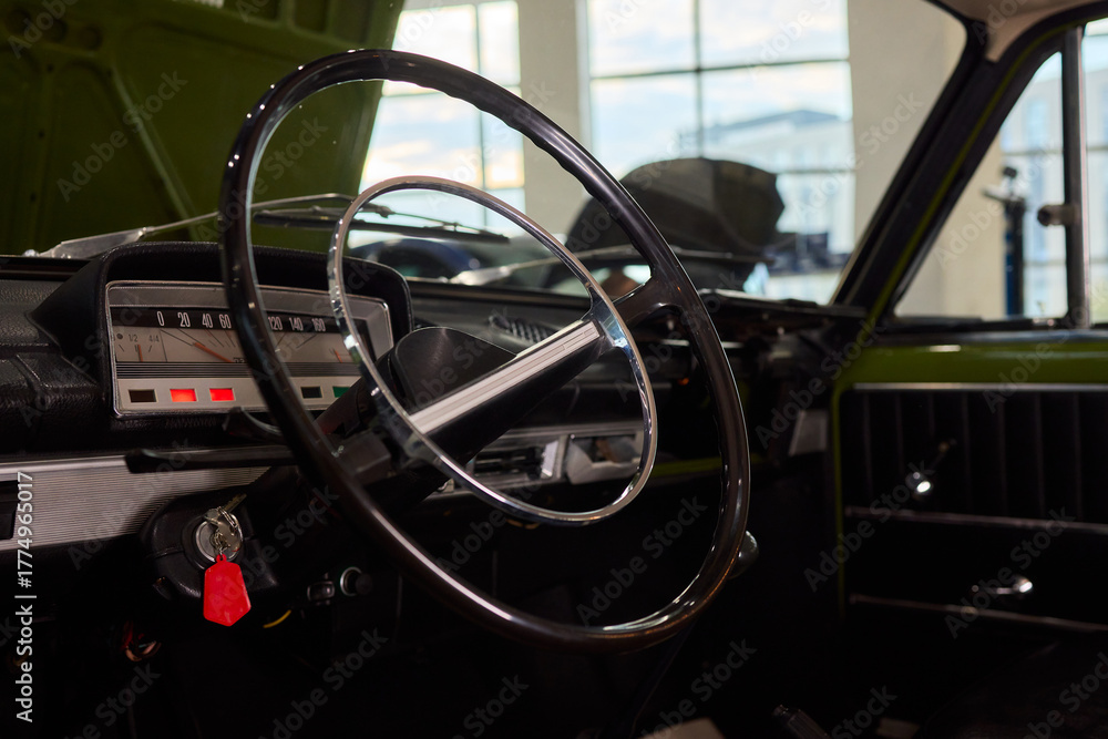 Obraz premium Closeup of a modern car steering wheel with control buttons for technology and convenience