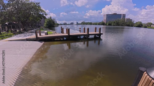 A view from a small pier extending over the water towards a peaceful river landscape.
