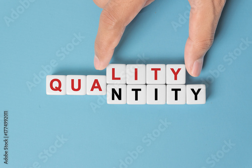 Quality over quantity concept. Hand changing word quantity to quality on dice.