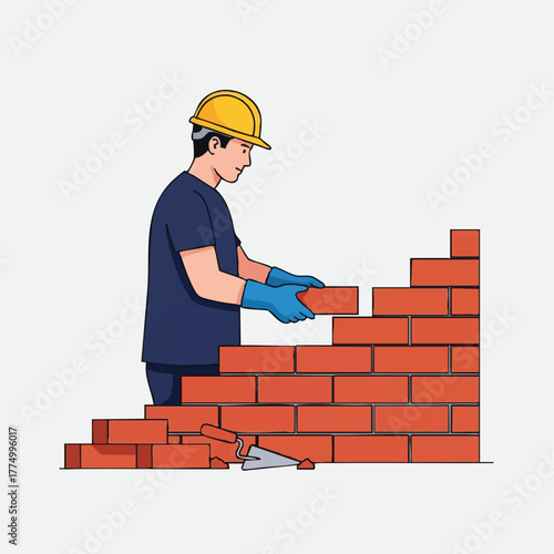 A construction worker in a hard hat and gloves carefully places a brick to build a red brick wall, showcasing the process of construction.