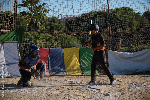 Obraz na płótnie Young baseball players training, catcher catching ball while batter preparing to