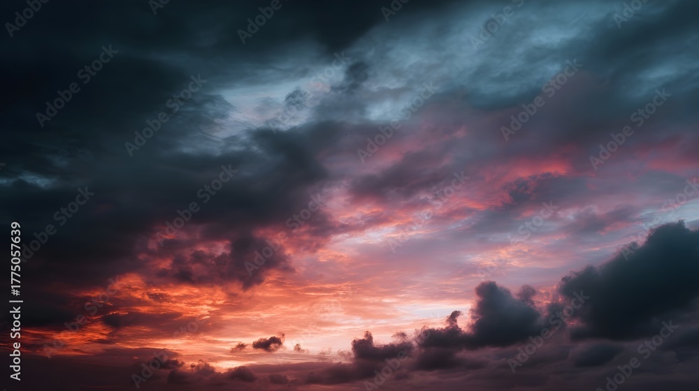 Obraz premium A dramatic twilight sky filled with fiery orange and pink clouds creating a moody and serene atmosphere