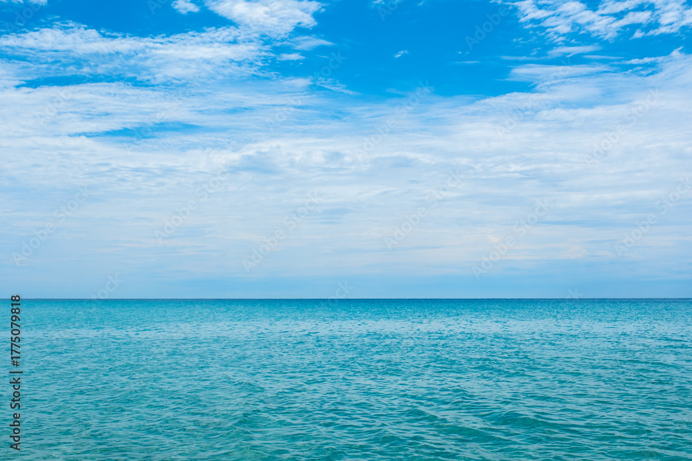 Obraz premium Nature of the ocean and blue sky Summer with sunshine, sandy beaches, clear blue waters sparkling against the blue sky. on an island with good ecology and environment Background for summer vacation