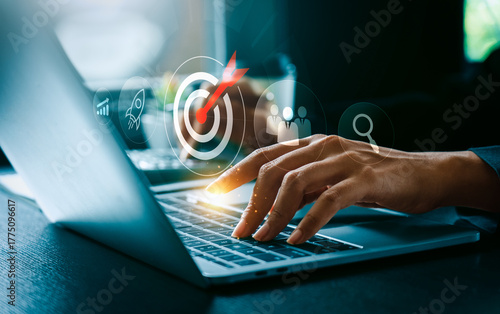 Business goal and digital strategy success concept with businessman typing on laptop computer and futuristic target icon surrounded by growth chart, rocket launch, teamwork innovation for achievement