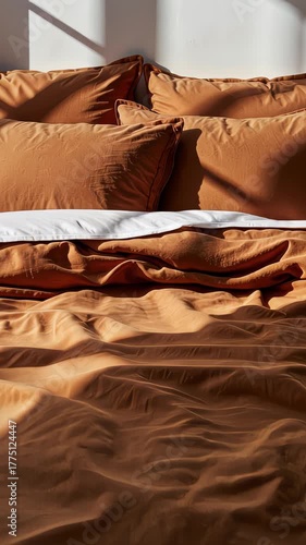 Cozy Bedroom Scene with Sunlit Earthy Toned Bed and Soft Pillows Creating an Inviting Atmosphere in a Tranquil Sunlit Setting