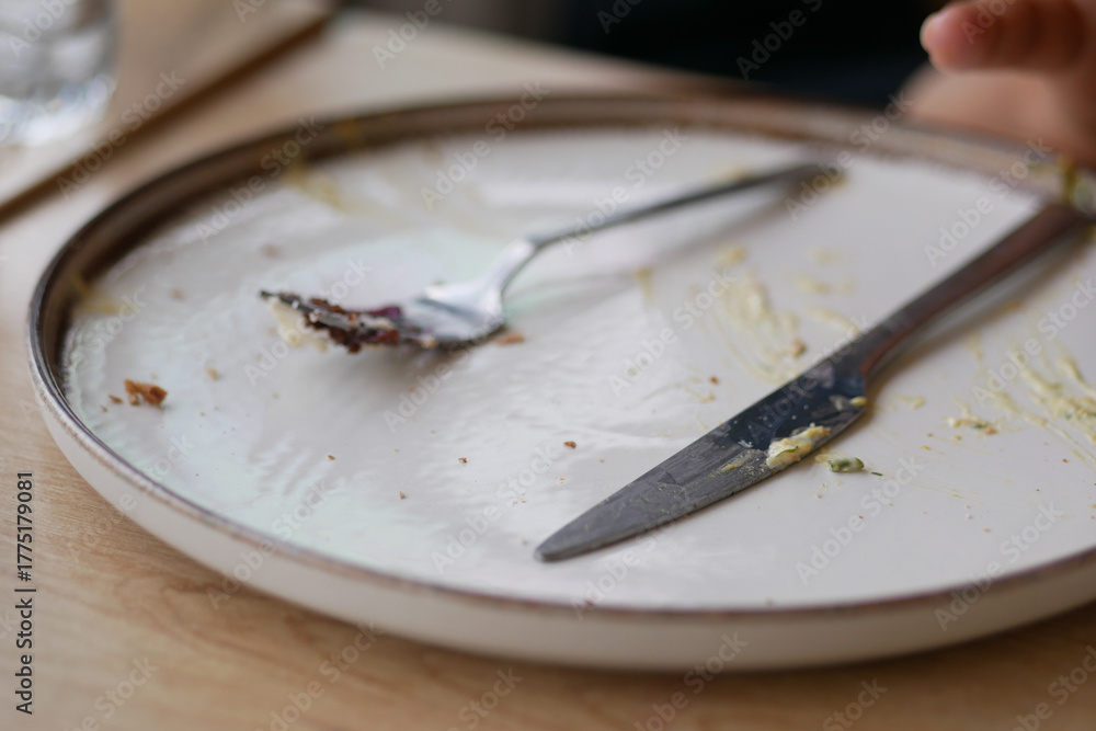 Fototapeta premium Empty plate after a satisfying meal at a cozy restaurant