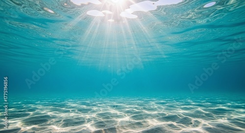 Underwater view, sun rays, clear blue ocean, sandy sea floor