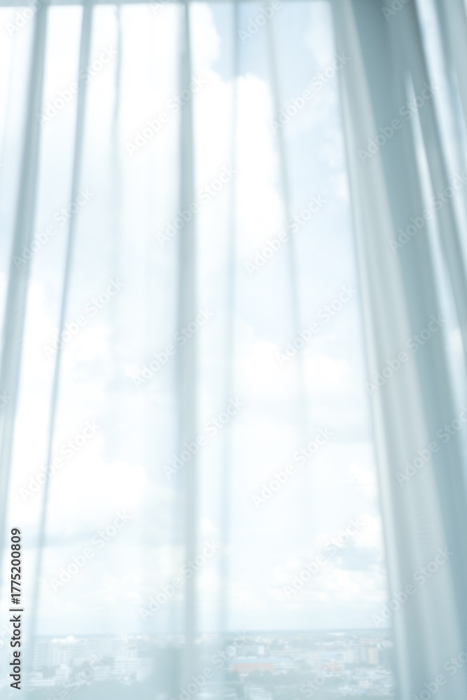 Fototapeta premium Sheer curtains draped over window, allowing soft light. Serene atmosphere invites relaxation.